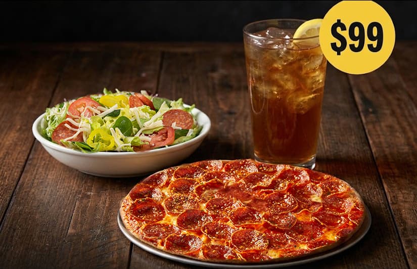 A Donatos Individual pepperoni pizza, a side salad, and a glass of fresh-brewed iced tea with lemon on a wooden table, with a $99 badge